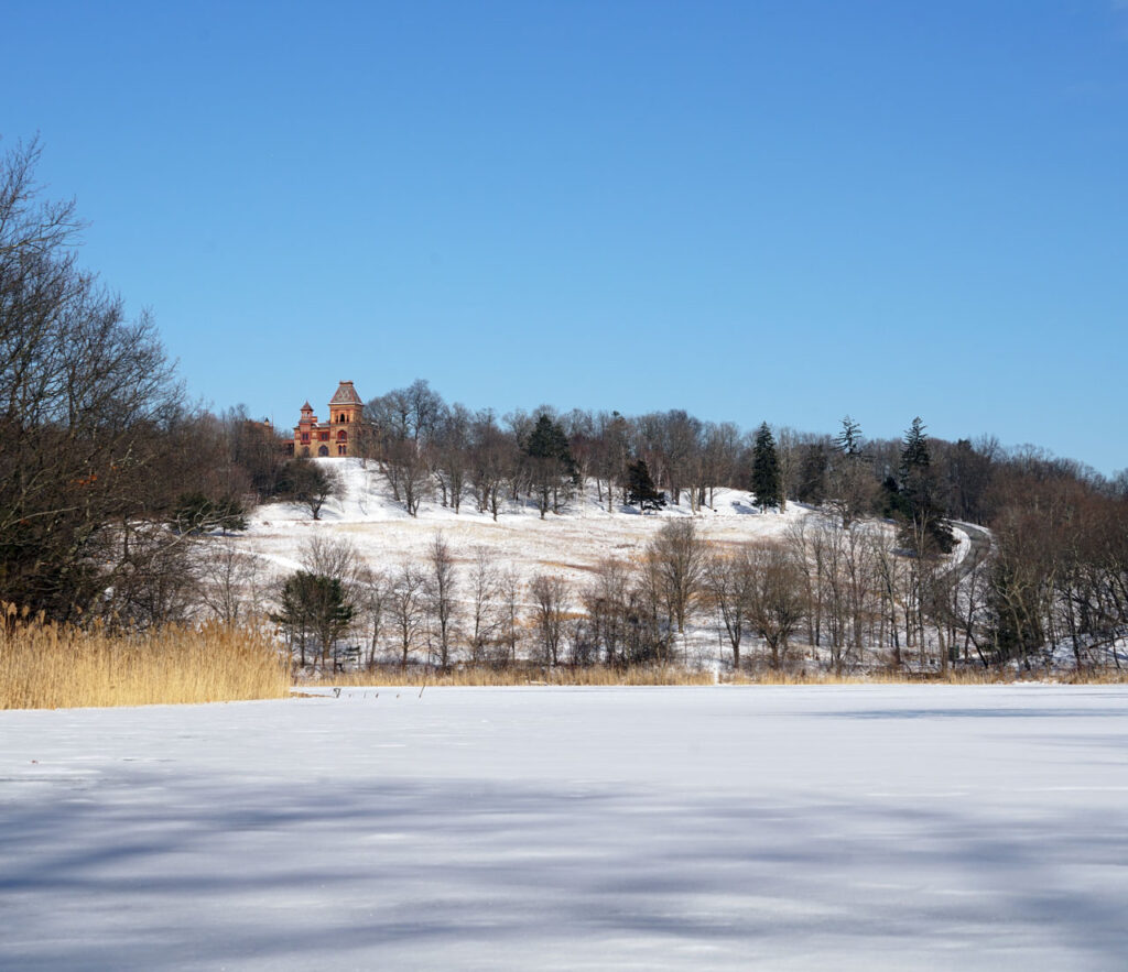 The view of The Park and the Olana House from the middle of the frozen lake, January 2025. Photo by Annik LaFarge, author of Composing Olana