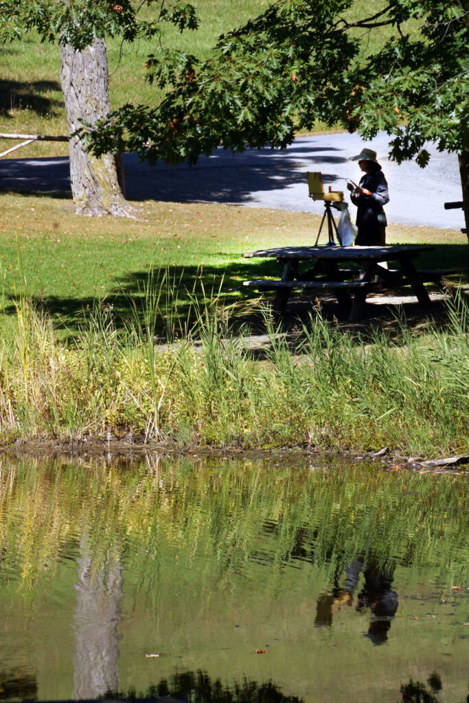 An artist working en plein air, with her reflection in the Olana Lake, September 2013. Photo by Annik LaFarge, author of Composing Olana