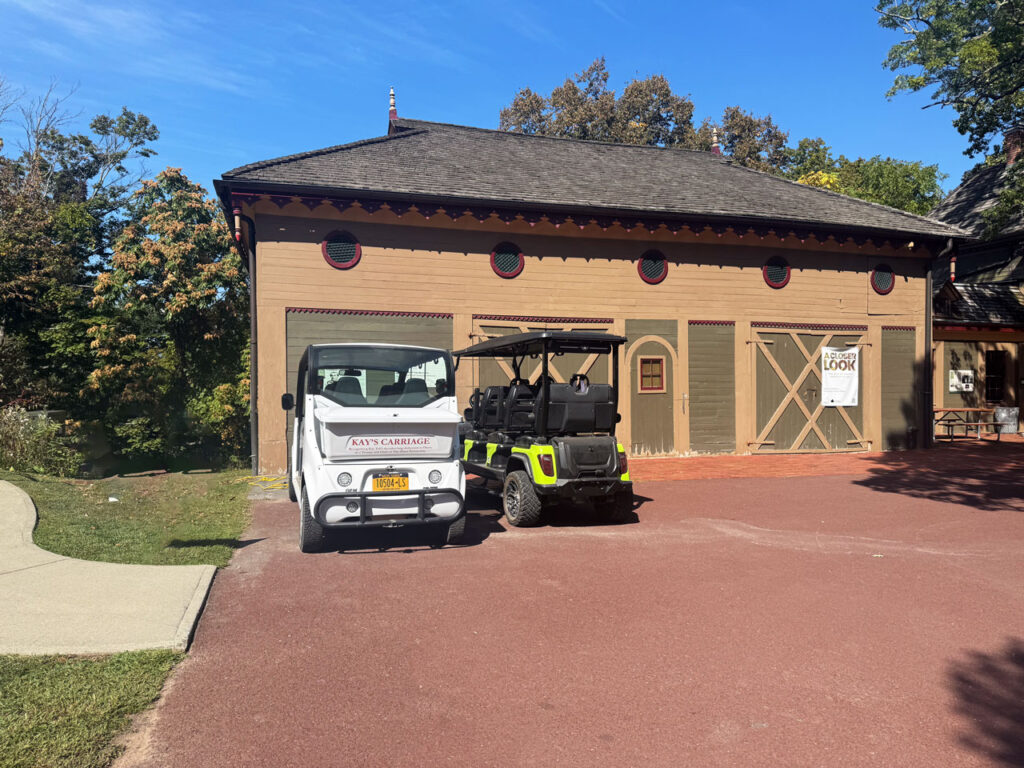 Kay's Carriage, the first electric tour vehicle, next to a more recent model. Both are parked outside the former stable at Olana, which was completed in 1870 by a local carpenter named Amos Story. Photo by Annik LaFarge, author of Composing Olana