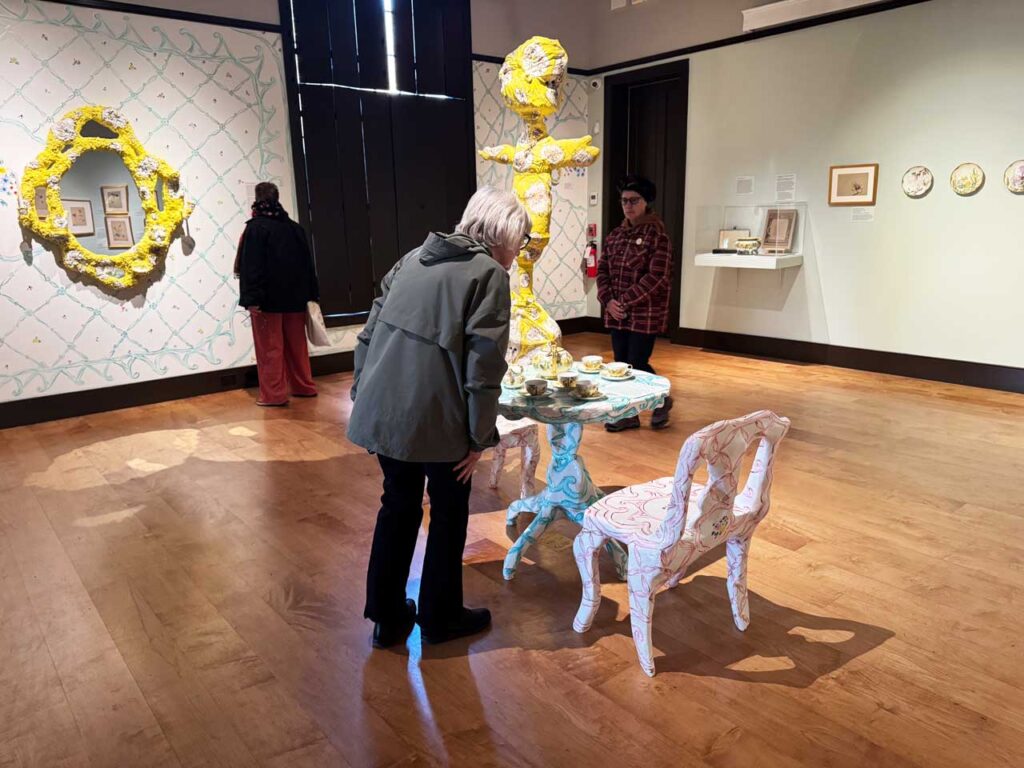 A visitor admires Emily Cole's tea set in the New Studio at the Cole Site. Photo by Annik LaFarge, author of Composing Olana